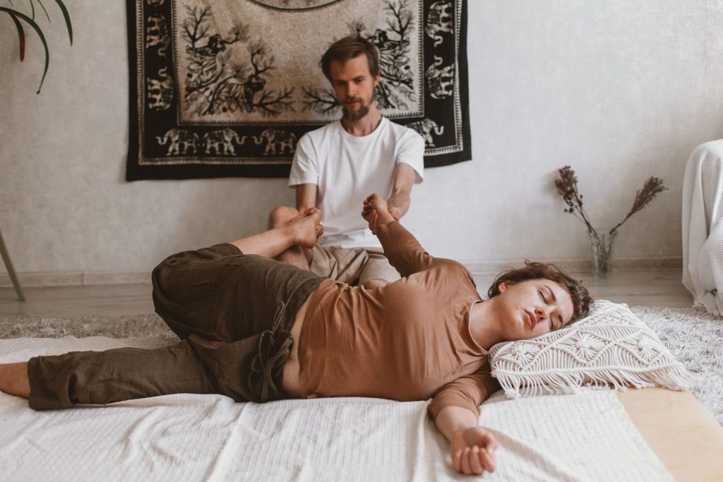 Therapist performing assisted stretching during a Thai massage session
