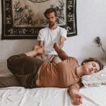 Therapist performing assisted stretching during a Thai massage session